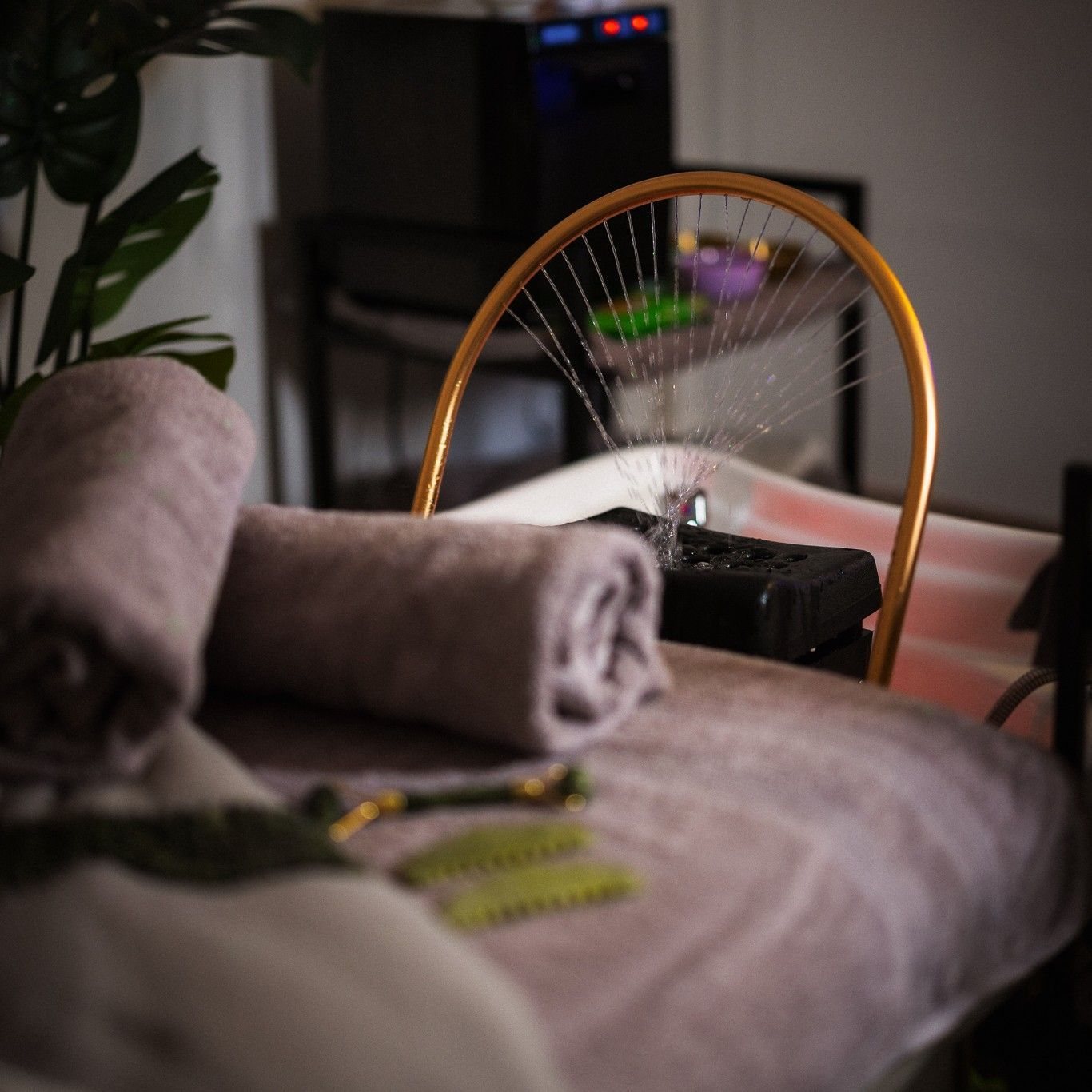 The treatment bed made up with rolled towels beneath the gold rainfall halo