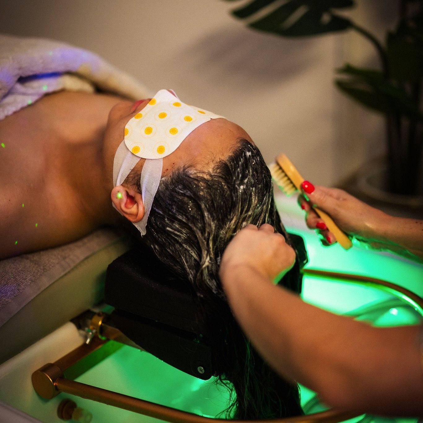 A scalp scrub worked in with a brush under green light
