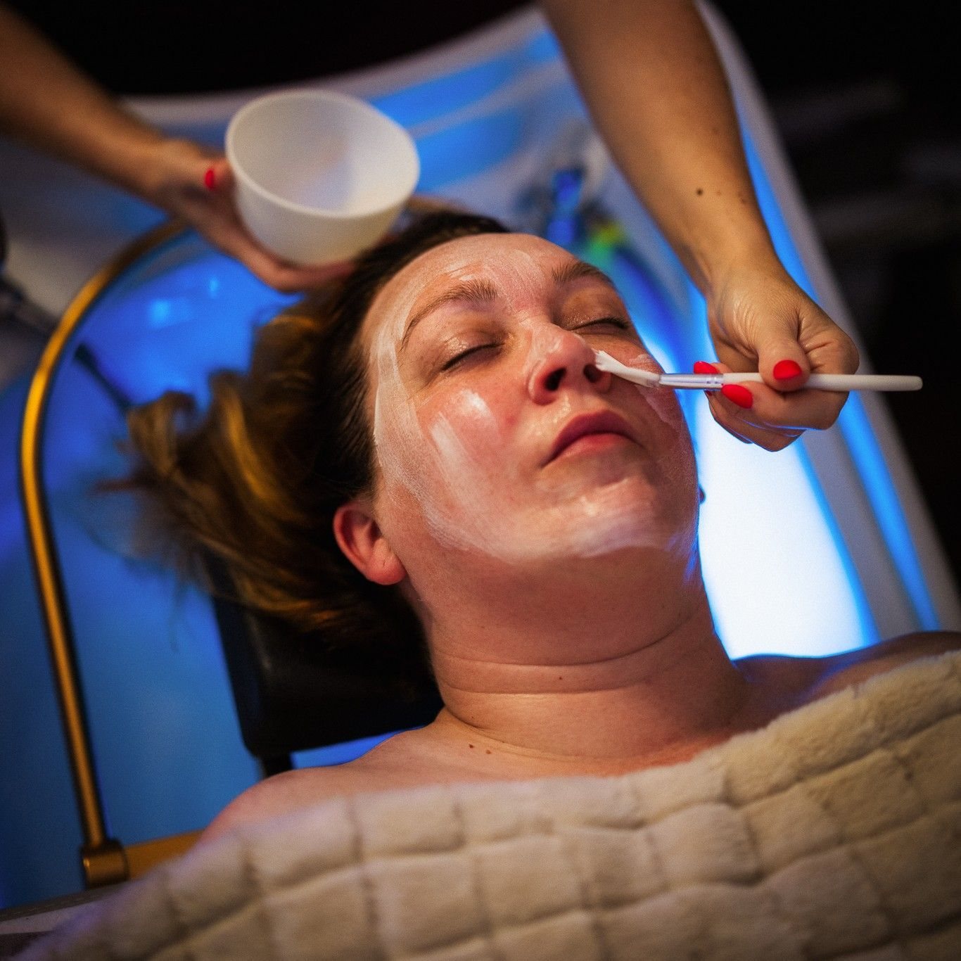 A face mask being brushed on during the holistic facial